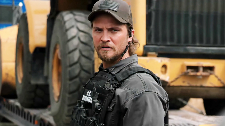 Kayce (Luke Grimes) standing in front of a truck on "Marshals."
