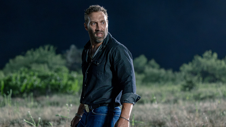 Jai Courtney's Rob-Will Jackson looks worried as he stands in a field at night in Dutton Ranch