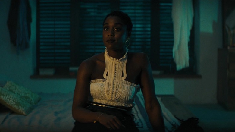 Agent Nomi sits on Bond's bed