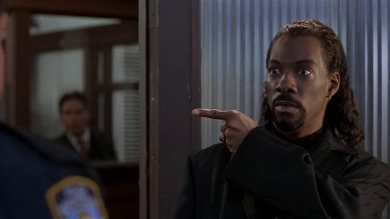 Maximilian poiting to something in front of a cop in Vampire in Brooklyn