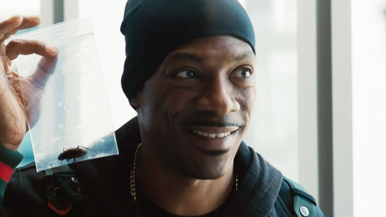 Eddie Murphy as Darnell Davis holds up a ziploc with a bug inside in Tower Heist