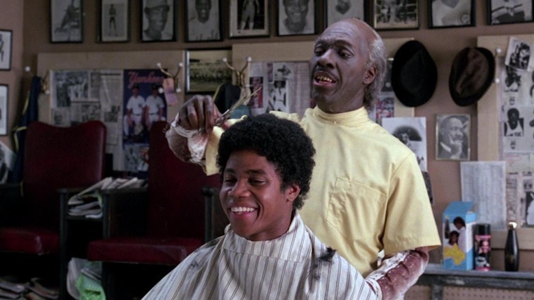 Eddie Murphy as Clarence cuts the hair of Cuba Gooding Jr. as an unnamed customer in Coming to America