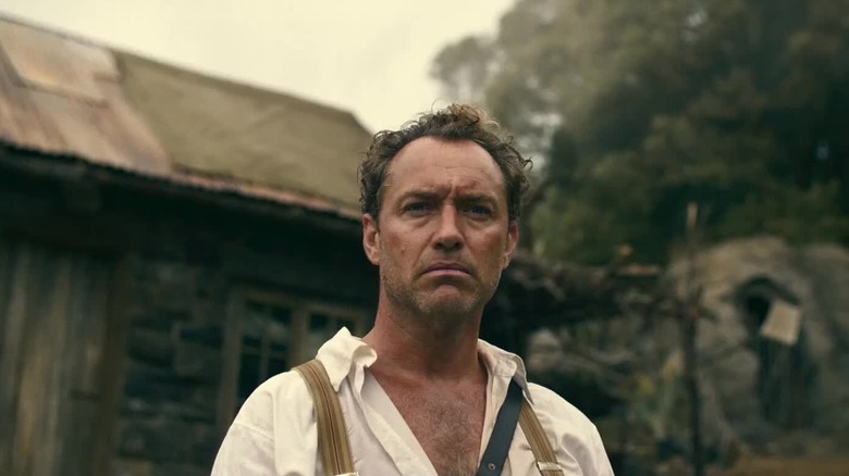 Jude Law as Ritter frowning in front of his house in Eden