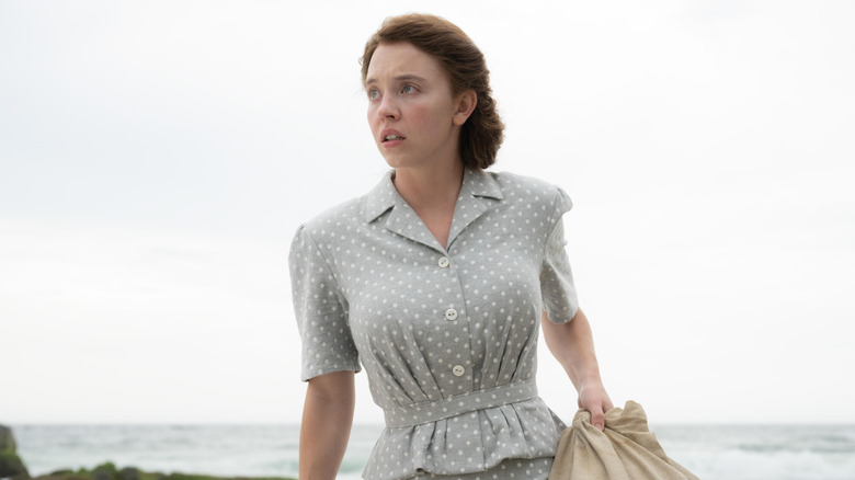 Sydney Sweeney as Margaret carrying her bags on the beach in Eden