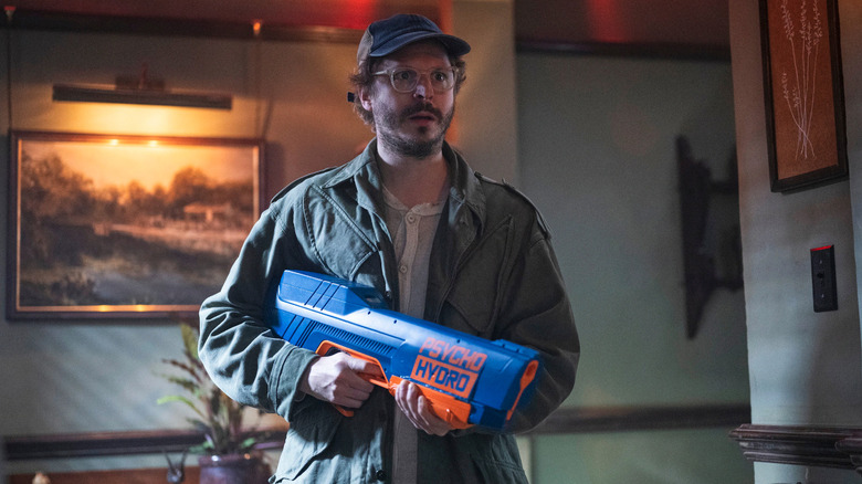 Elton Parrakis (Michael Cera) happily electrocuting a bunch of Hunters with a water gun in The Running Man