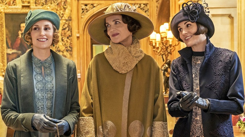 Laura Carmichael, Elizabeth McGovern and Michelle Dockery standing together in "Downton Abbey"