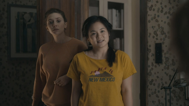 Elizabeth Olsen's Leigh Shaw stands behind Kelly Marie Tran's Jules Shaw in s a bedroom doorway in Sorry for Your Loss