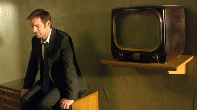 Joe Miller sitting next to a vintage TV on The Lost Room
