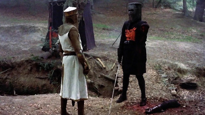 ग्रॅहम चॅपमन किंग आर्थरच्या भूमिकेत मॉन्टी पायथन आणि होली ग्रेलमध्ये ब्लॅक नाइट म्हणून हात नसलेल्या जॉन क्लीसचा सामना करतो