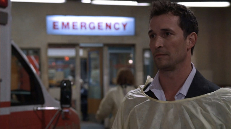 Noah Wyle as Carter standing outside emergency room looking concerned in ER