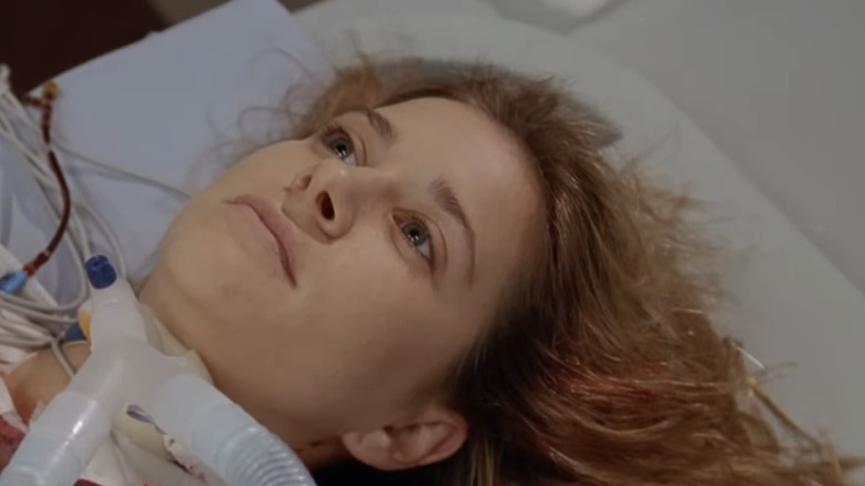 Kellie Martin as Lucy lying with blood on gown and tube in throat in ER