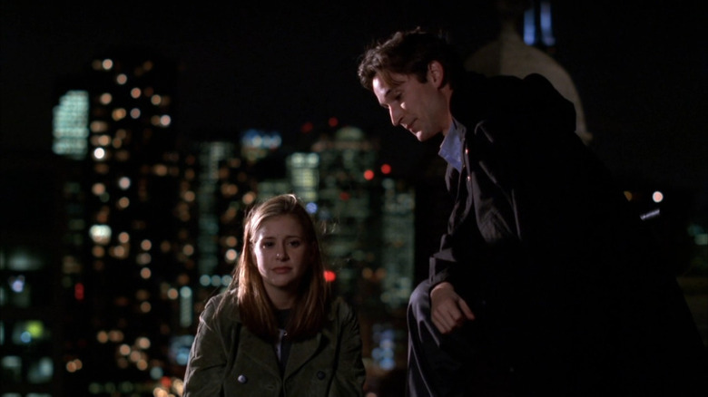 Noah Wyle as Carter standing on roof next to teary-eyed Kellie Martin as Lucy in ER