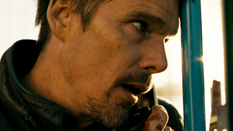 Travis Conrad d'Ethan Hawke parle au téléphone dans une cabine téléphonique dans 24 Hours to Live