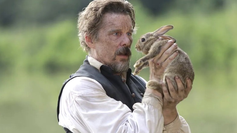 Ethan Hawke as John Brown holds up a rabbit in The Good Lord Bird