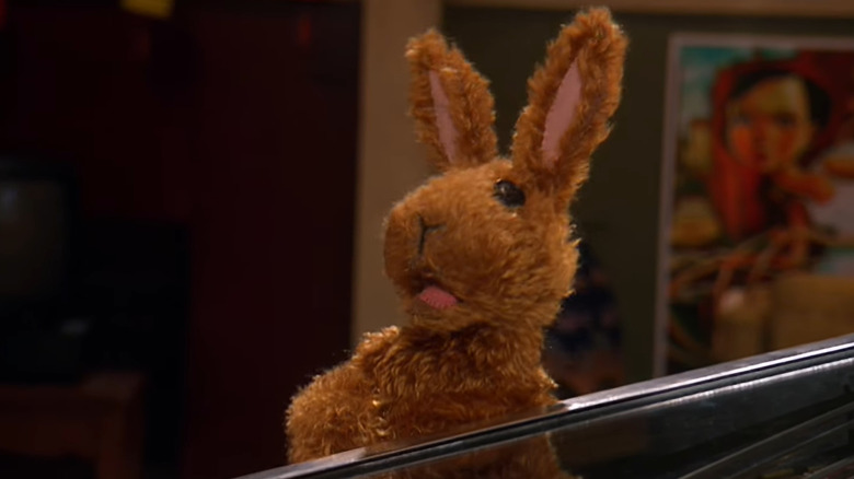 Greg leunt tegen een flipperkast in Greg the Bunny