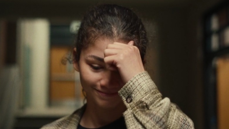 Rue smiling hand on forehead