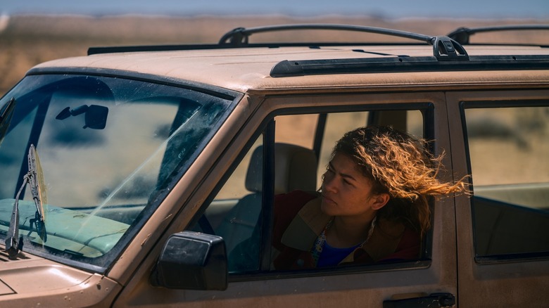 యుఫోరియాలో ఆమె వెనుక జుట్టుతో ఎగురుతూ కారులో ర్యూ