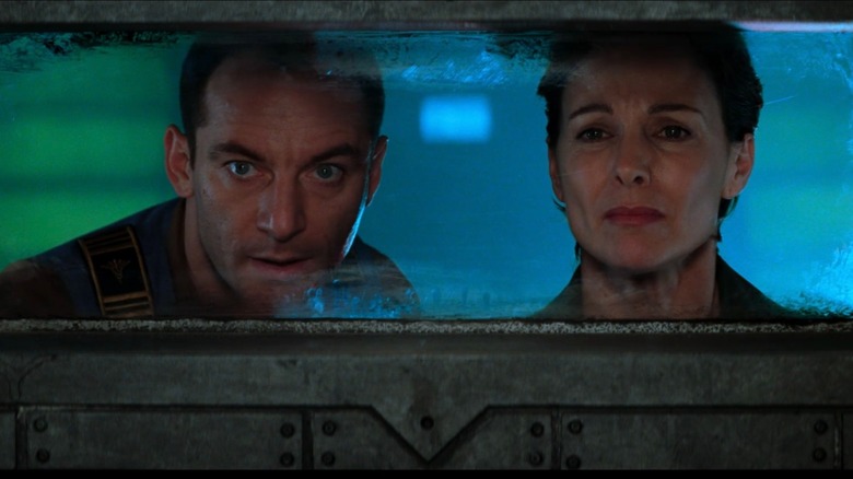 Jason Isaacs as DJ and Kathleen Quinlan as Peters looking through a window in Event Horizon