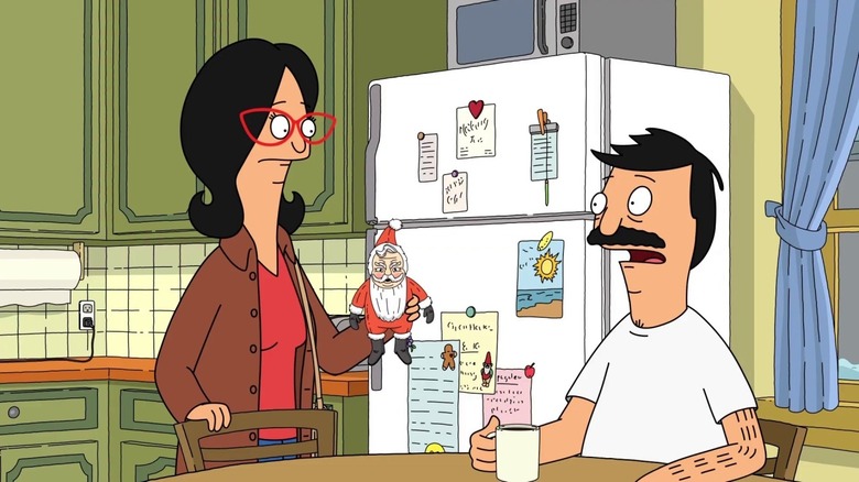 Linda holds up a Santa statue to Bob