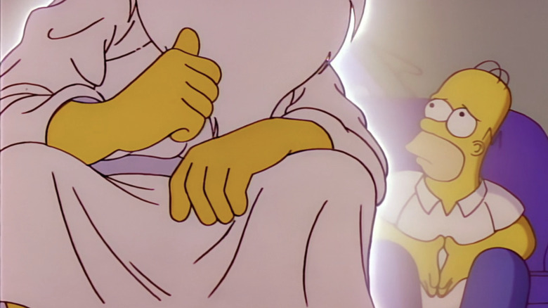 God zit naast Homer Simpson op een bank in The Simpsons
