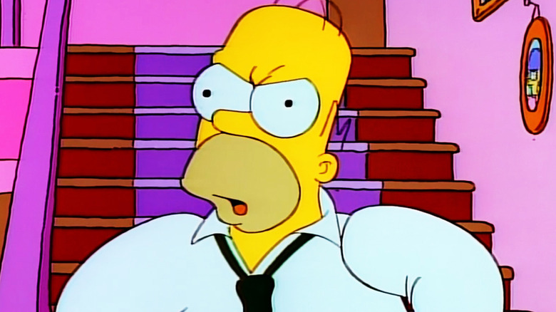 Homer Simpson looks mad in closeup as he stands in his house in The Simpsons