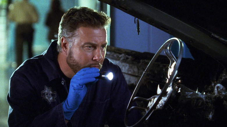 Grissom shining a flashlight on a steering wheel on "CSI"
