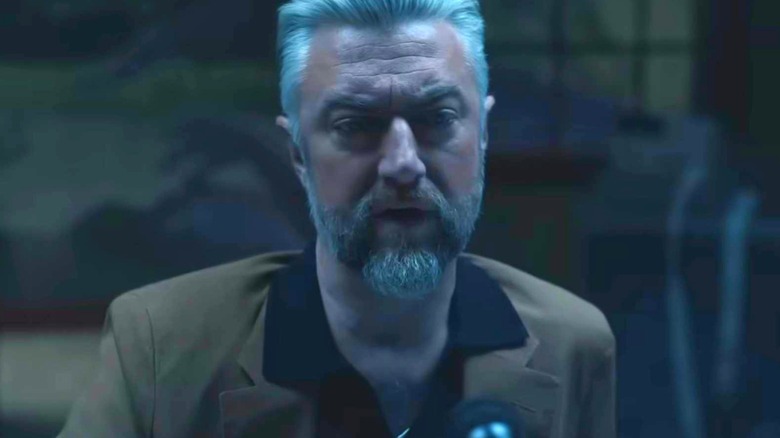 Sean Gunn as Maxwell Lord in a dark room