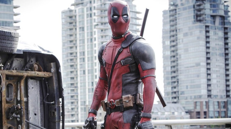 Deadpool stood next to an upturned car in Deadpool