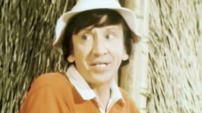 Bob Denver's Gilligan looks across frame as he stands next to a hut in Rescue from Gilligan's Island