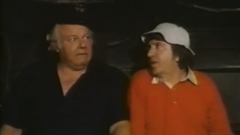Alan Hale Jr.'s Captain Jonas Grumby sits beside Bob Denver's Gilligan on a plane in The Castaways on Gilligan's Island