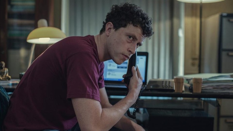 Finnegan Oldfield as Guillaume Lucchesi, taking a phone call on Gone for Good