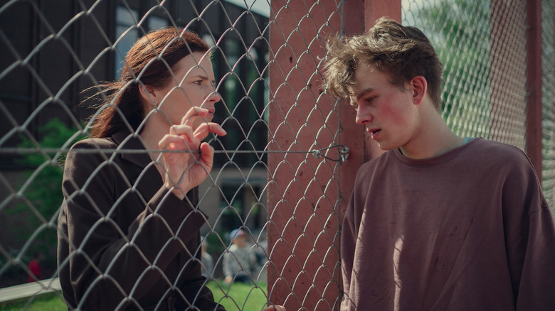 Magdalena Boczarska and Krzysztof Oleksyn as Anna and Adam, speaking through a fence on Hold Tight