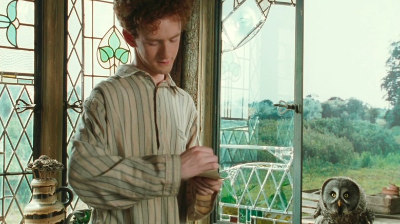 Chris Rankin's Percy Weasley reads owl post near an open window in Harry Potter and the Chamber of Secrets
