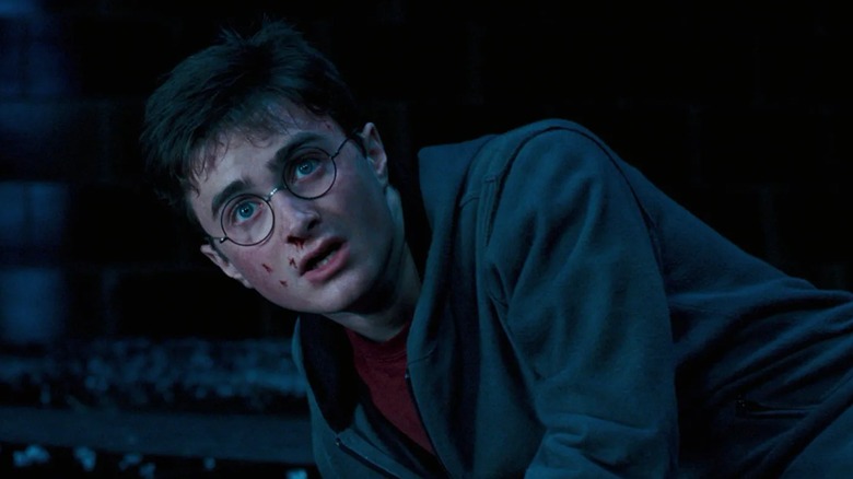 Daniel Radcliffe's Harry Potter looks defeated, knocked to the ground with cuts on his face, in Harry Potter and the Order of the Phoenix