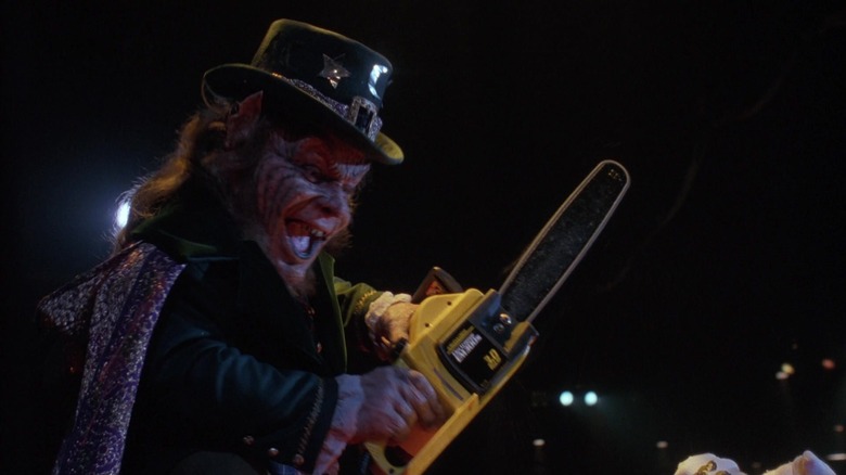 Warwick Davis as Lubdan, excitedly wielding a chainsaw in Leprechaun 3