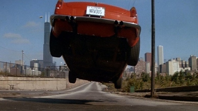 A red sports car with a license plate reading NRVOUS flies through the air in Ferris Bueller's Day Off