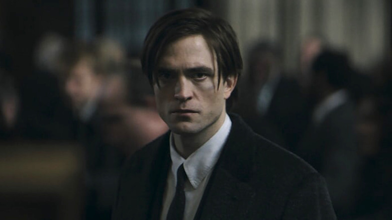 A haggard Bruce Wayne (Robert Pattinson) stares intensely in The Batman