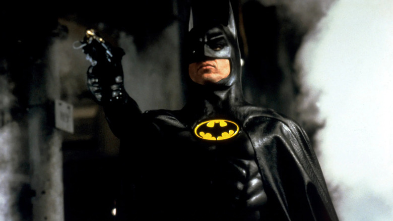 Michael Keaton as Batman, aiming his grapple gun, in the 1989 Batman movie