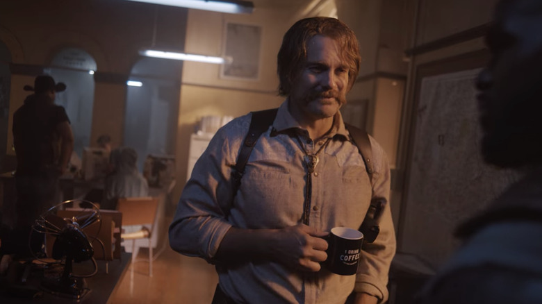 Chalmers holding a cup of coffee
