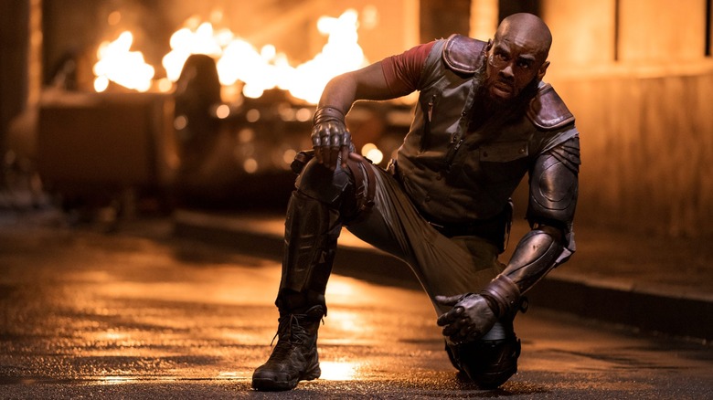 Jet Black kneeling in the street in front of a fire