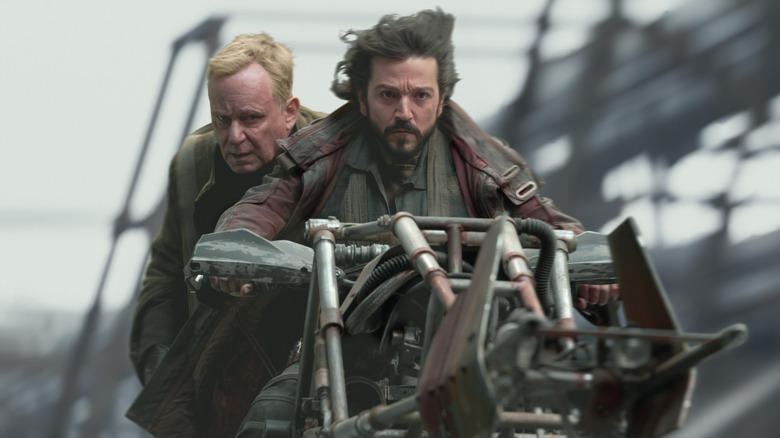 Cassian Andor and Luthen Rael riding a speeder bike on Ferrix in Andor season 1