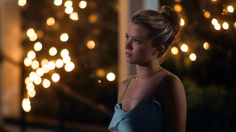 Taylor with her hair up in a green dress in fairy lights looking disappointed on The Summer I Turned Pretty