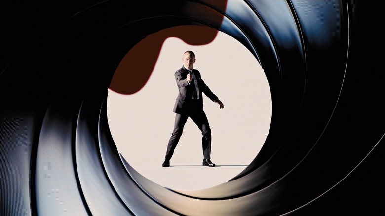 Daniel Craig com uma pistola na mão emoldurada por um barril de arma na introdução a um filme de James Bond