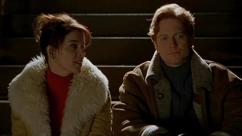 Eric Stoltz and Annabella Sciorra sit on steps 