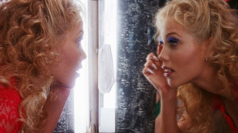 Elizabeth Berkley looking at herself in the mirror in Showgirls