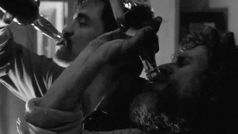 Ephraim Winslow and Thomas Wake chug booze in The Lighthouse
