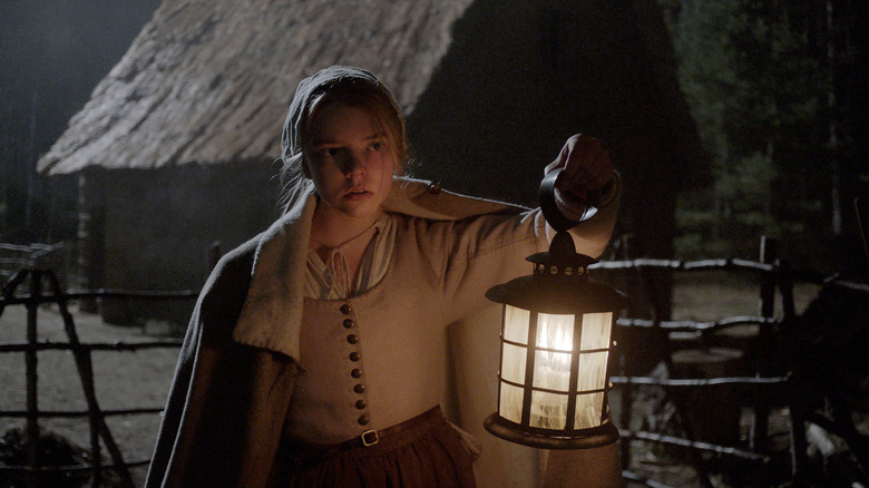 Thomasin holds up a lantern in The Witch