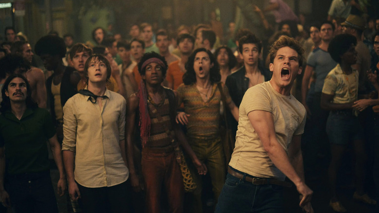 A crowd of angry people in late 60s clothing