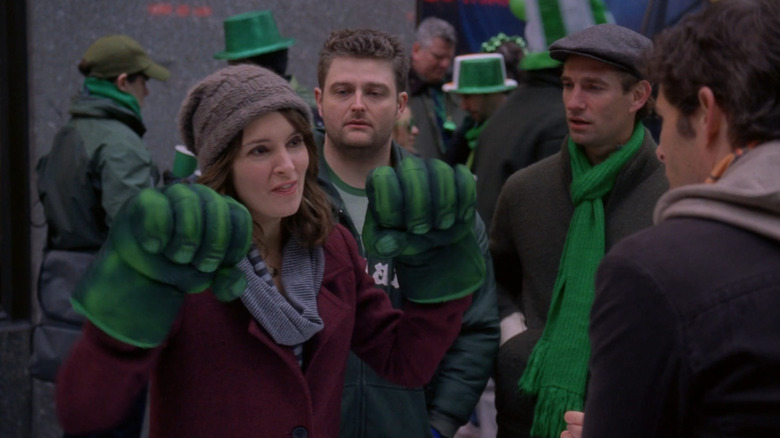 Liz wearing fake Hulk hands and talking to Criss on 30 Rock