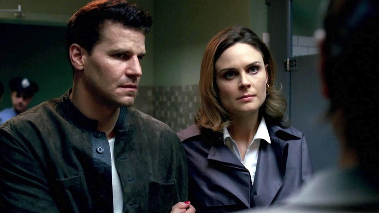 David Boreanaz as Booth stands next to Emily Deschanel as Brennan in Bones
